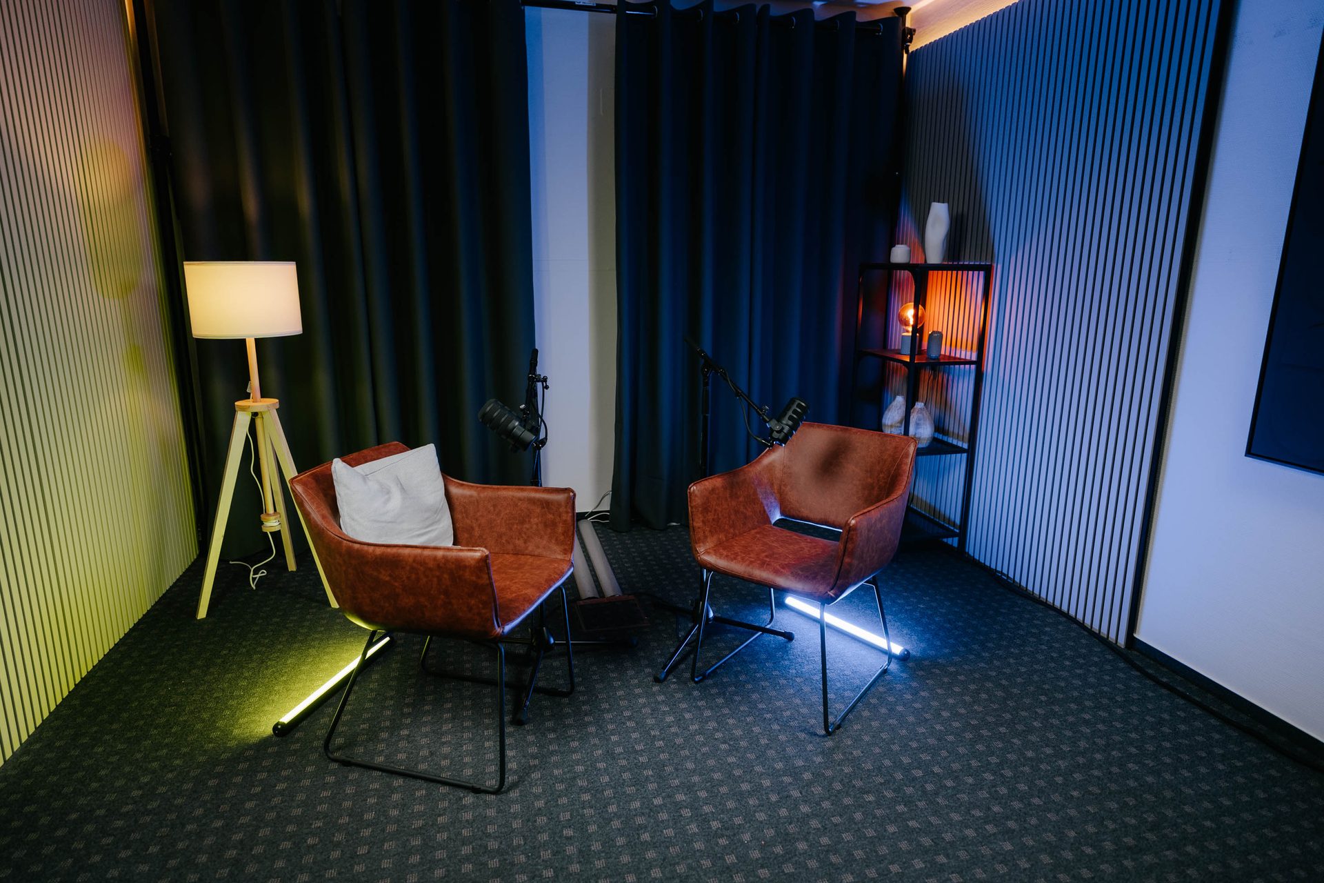 Zwei Ledersessel mit Mikrofonen und Stehlampe im Studio Eiche