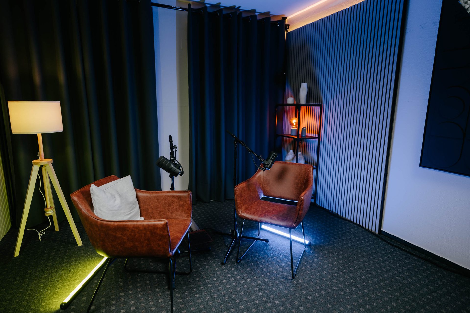 Studio Eiche in Freiburg – dunkles Business-Podcast-Studio mit Ledersesseln, Mikrofonen und warmem Licht