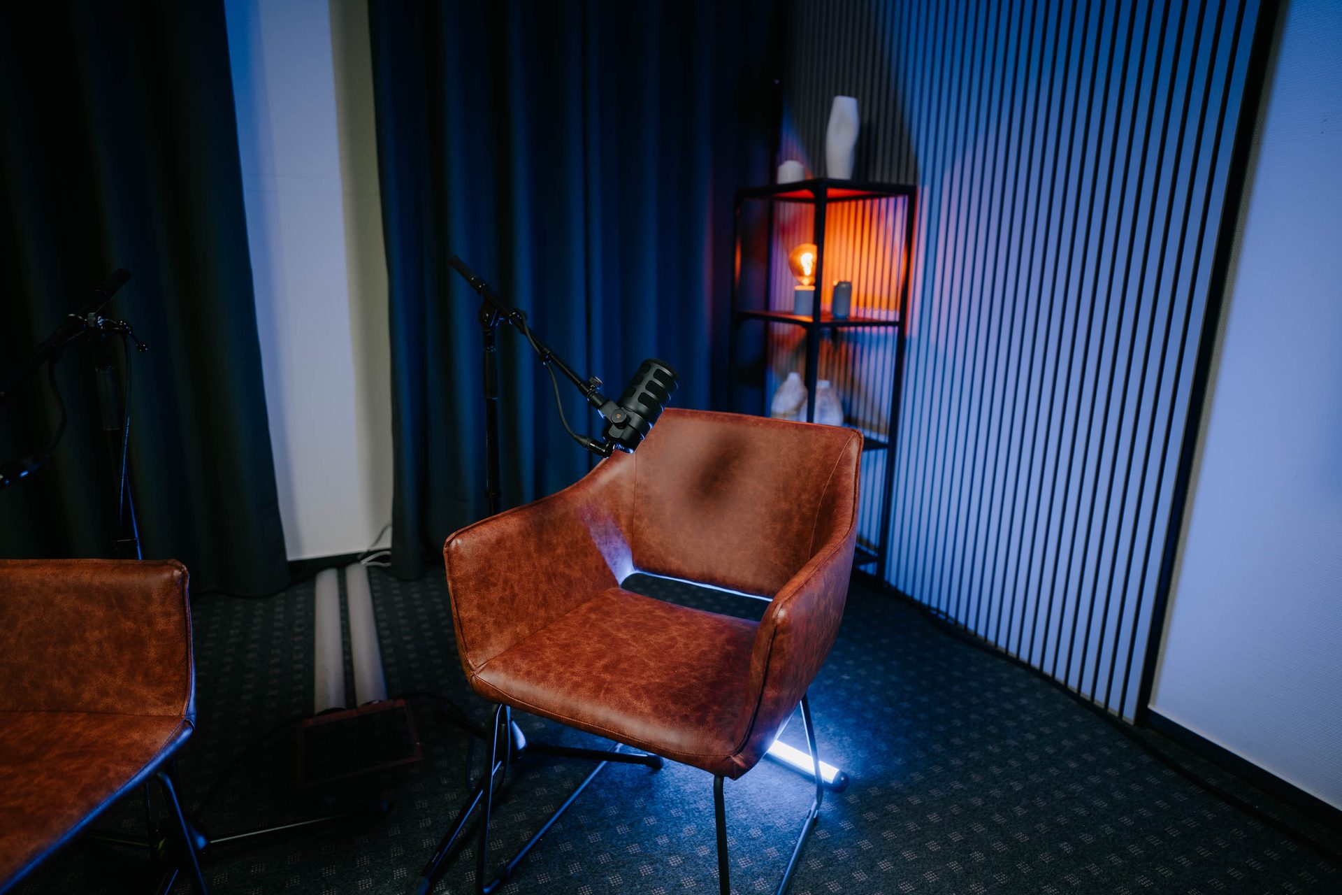 Gästeplatz mit Mikrofonarm vor Akustikpaneelen im Studio Eiche