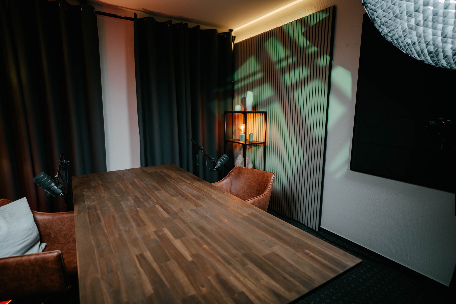 Holztisch mit Mikrofonen aus Gastperspektive im Studio Eiche